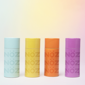 4 different role on versions of the Nöz sunscreen in the available colors. Left to right position of colors, first blue, then yellow, orange and lastly purple. 